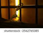 Handcuffs on Jail Bed with Bars - Prison Scene with Dramatic Lighting and Dark Background