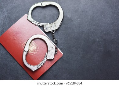 Handcuffs And Passport On Dark Background Suggesting Illegal Immigration Problem