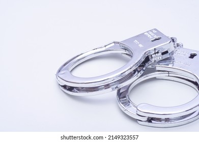 Handcuffs placed on a white table - Shutterstock ID 2149323557