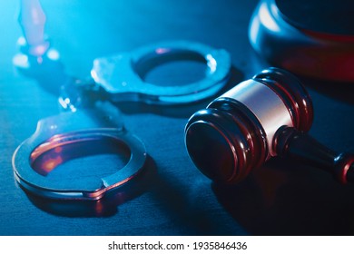 Handcuffs and wooden gavel. Crime and violence concept. - Shutterstock ID 1935846436