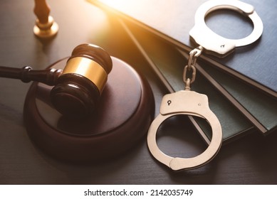 Handcuffs and wooden gavel. Crime and violence concept. - Shutterstock ID 2142035749