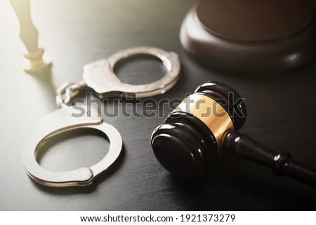 Handcuffs and wooden gavel. Crime and violence concept.