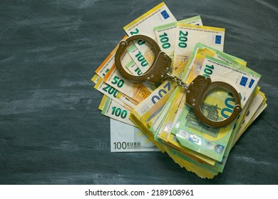 Handcuffs,euro Bills On Black Chalkboard Background. Economic Crimes.Arrest On Bank Accounts And Property In Europe. Corruption And Waste Of The Budget In The European Union