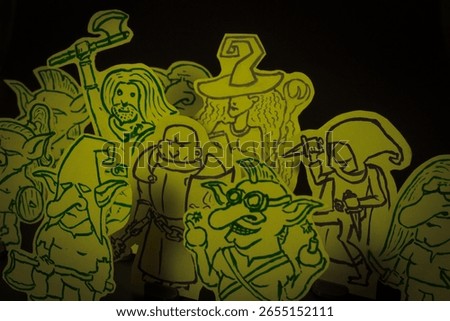 Hand-drawn fantasy paper miniatures of goblins and adventurers, including a wizard, paladin, warrior, and rogue. 