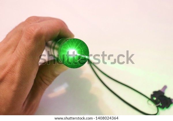 Handed green high power laser pointer\
key secured strong light beam shining at\
camera