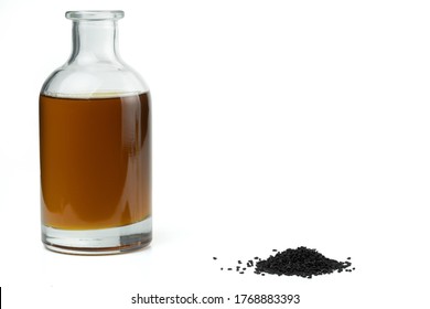 A Handful Of Black Cumin Seeds And Black Seed Oil In A Bottle Isolated On A White Background.