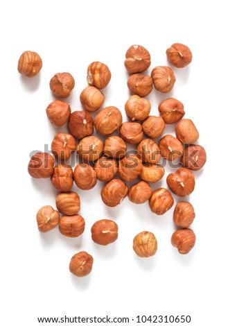 A handful of hazelnuts scattered on a white background, isolated