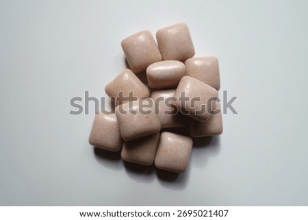 Handful of pink rectangular pieces of chewing gum from above