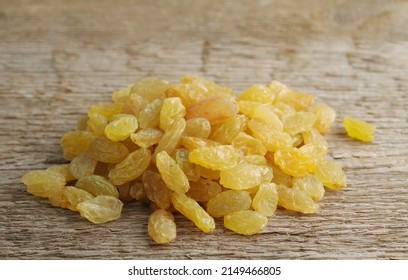 A Handful Of Yellow Raisins On A Woody Texture Background. Selective Focus.