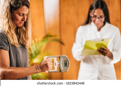 Handgrip strength test with digital hand dynamometer at a functional medicine center - Shutterstock ID 1823842448