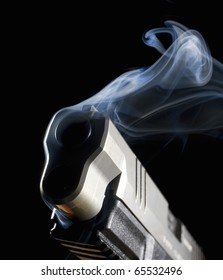 Handgun With Its Muzzle In The Dark With Smoke Coming Out