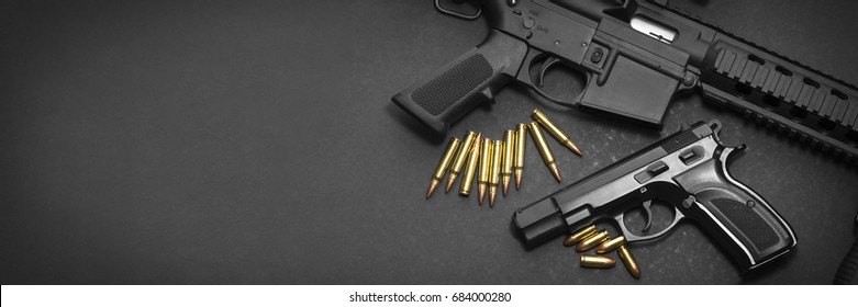 Handgun with rifle and ammunition on dark background with copy space 