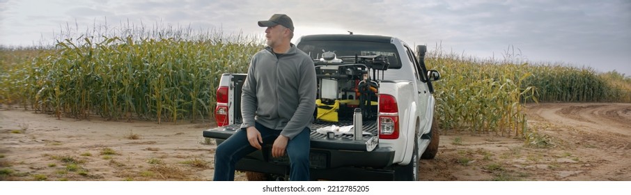 HANDHELD 50s Caucasian Male Farmer Looking Through The Papers While Sitting On The Back Of His Truck