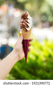 Hand-held Cone Ice Cream On Green Background