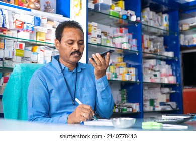 handheld shot of pharmacist taking order from mobile phone at medical retail store from customer - conept of small business, working professional and communication skills - Powered by Shutterstock