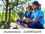 handheld shot of Village school girl kids seriously busy working on laptop - concept of education, technology and knowledge