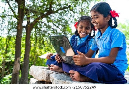 handheld shot of Village school girl kids seriously busy working on laptop - concept of education, technology and knowledge