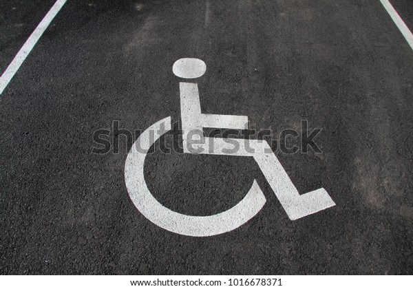 Handicap icon. Parking lot with handicap\
sign and symbol. Empty handicapped reserved parking space with\
wheelchair symbol. Disabled person sign. Copy\
space