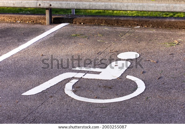 Handicap icon. Parking lot with\
handicap sign and symbol. Empty handicapped reserved parking space\
with wheelchair symbol. Disabled person sign. Copy\
space.