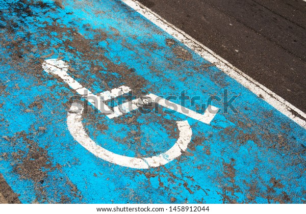 Handicap parking sign\
painted on road on parking space for disabled or handicapped people\
in parking lot