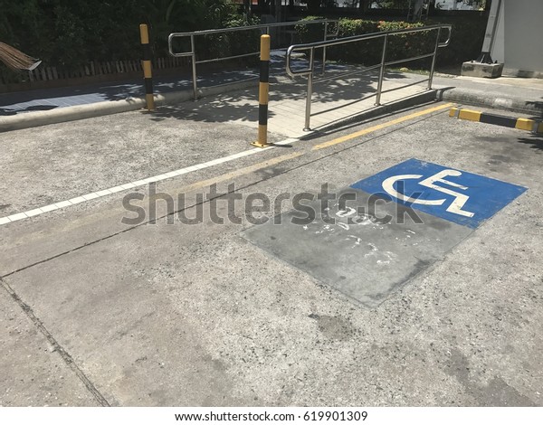 Handicap parking\
space outdoor. Ramp for the disabled. Slot empty space parking with\
cripple sign for\
cripple.