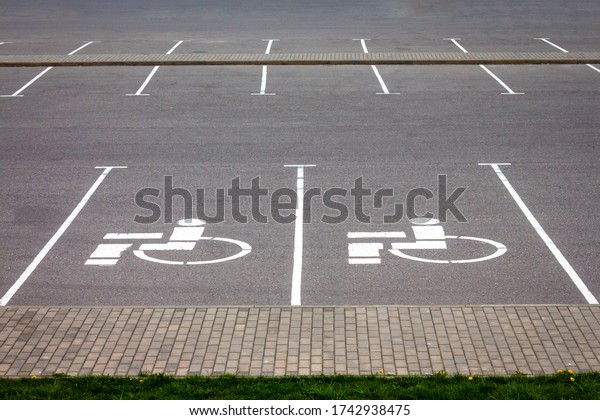 Handicap\
parking spot, white sign on black\
asphalt