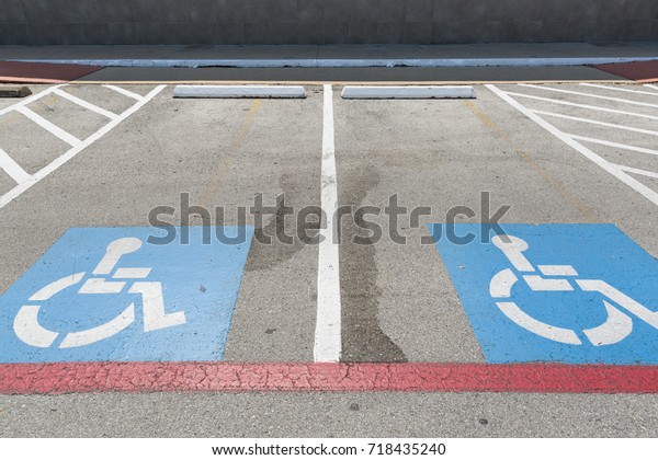 Handicap symbols on asphalt road, parking place\
reserved for disabled person or\
people