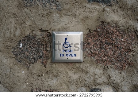 Handicapped “push to open” button on stone wall