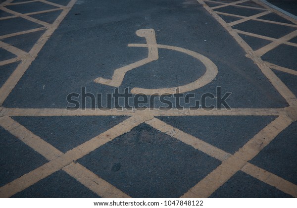 Handicapped disabled icon sign on parking area in car\
park .