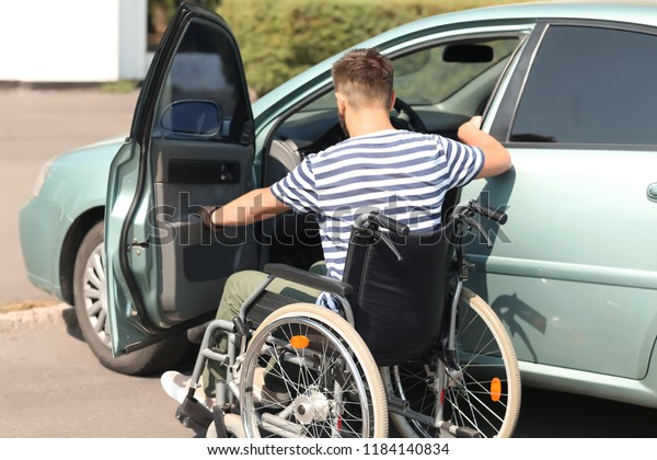 Handicapped man getting into his\
car