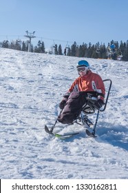 Handicapped Man Riding A Mono Ski From The Mountains, Adaptive Skiing And Winters Holiday For Disabled Men, Vacation In The Mountains