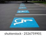 Handicapped parking signs on the ground in a parking lot.