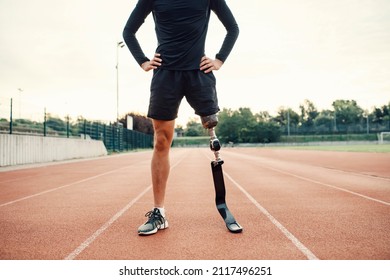 A handicapped runner standing on running track at stadium with hands on hips. - Powered by Shutterstock