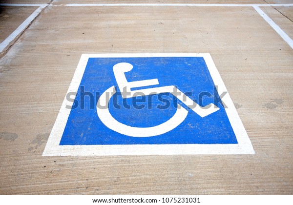 Handicapped sign painted on the floor to\
reserve parking lot for\
disabled.