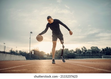 A handicapped sportsman with prosthetic leg dribble the basketball at stadium. - Powered by Shutterstock