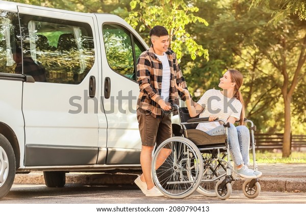 Handicapped woman\
and her husband near van\
outdoors