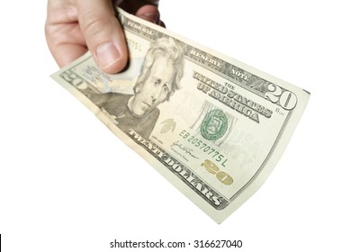 Handing A 20 Dollar Bill To Viewer. The Focus Is On The Near Edge Of The Bill. Isolated On A White Background.