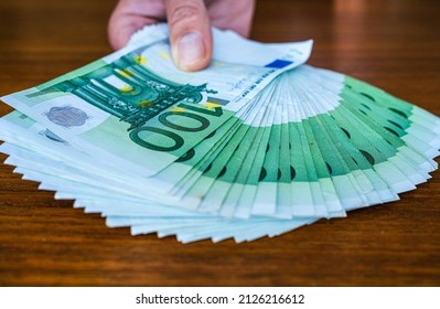handing over fanned out euro notes. Background image for financial topics, corruption, salary, present, bribe, payment amount or donation.