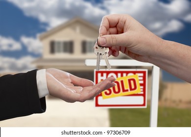 Handing Over The House Keys In Front Of Real Estate Sign And Sold New Home.