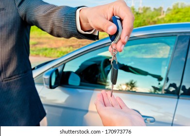 Handing Over Keys Of New Car Buyer