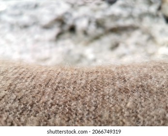 Hand-knitted texture close-up.  Natural hand-knitted wool shawl. Warm cozy knitted clothes or handmade plaid, blurred background. Russian down shawl made of goat or sheep wool