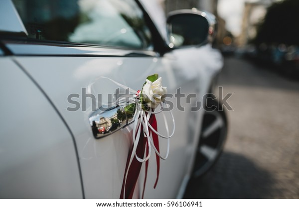 Handle of a car decorated with rose and ribbons\
for wedding ceremony