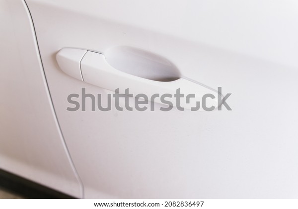 The handle of the car door is white. Lock and\
alarm system. Theft\
protection.