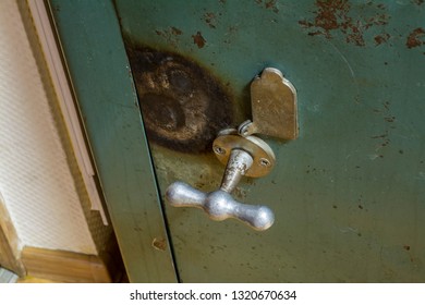 The handle of the old safe with traces of hacking