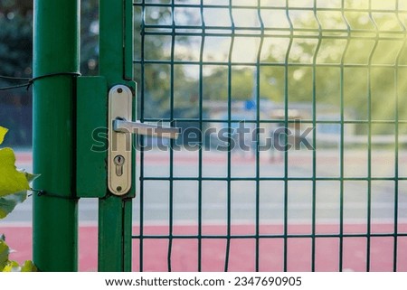 The handle for opening the door. The lock for the gate to the tennis court is made of stainless steel. Copy Space.