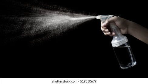 Handle A Spray Bottle To Spray Water Mist In The Air Against A Black Background.