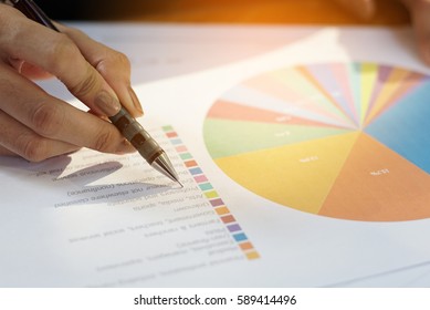 Handle using a pen with papers in forecast business concept