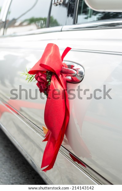handle\
wedding limousine decorated with red\
ribbon