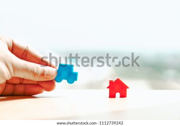 Handles\
hold car model and house model on wooden boards.Have a background\
office.Credit or loan and earning for home in the family.Use money\
to exchange or buy in business and real\
estate