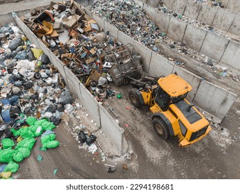 Handling construction waste on the landfill site, skid steer loader scooping and dumping dusty trash, aerial side view. - Powered by Shutterstock